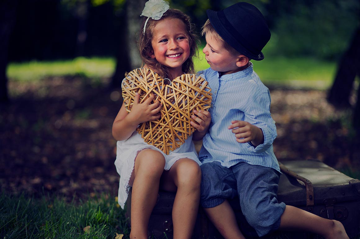 childern sitting holding a heart