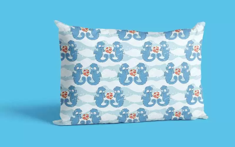 A preview of a design pattern having blue sea horses on it used on a white pillow